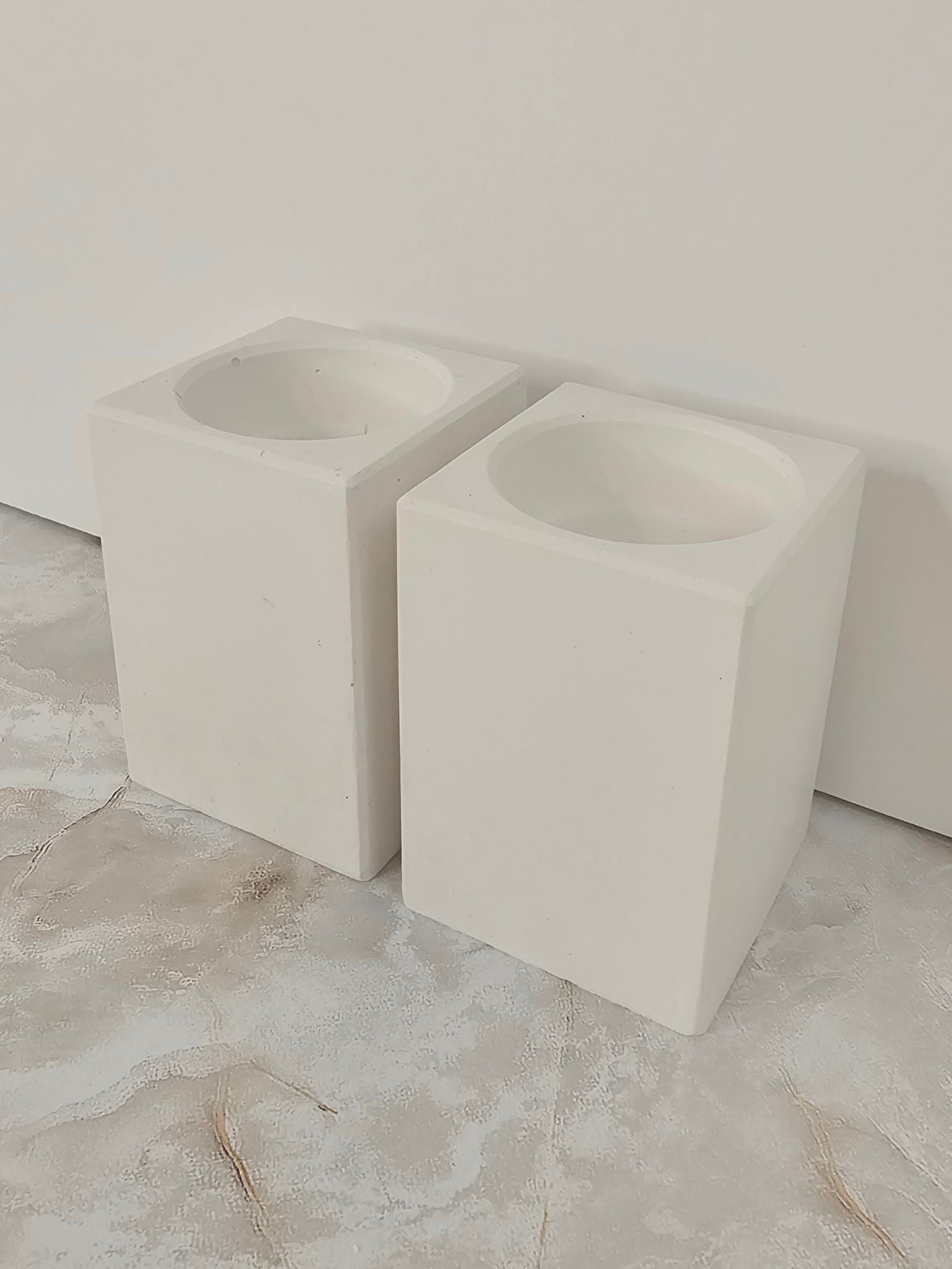 Two tall stone-look square cube candle holders on a marble surface, minimalist handmade home decor by Gifts LA
