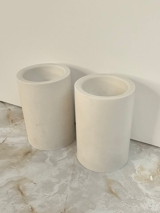 Two tall stone-look cylinder candle holders on a marble surface, minimalist handmade decor by Gifts LA