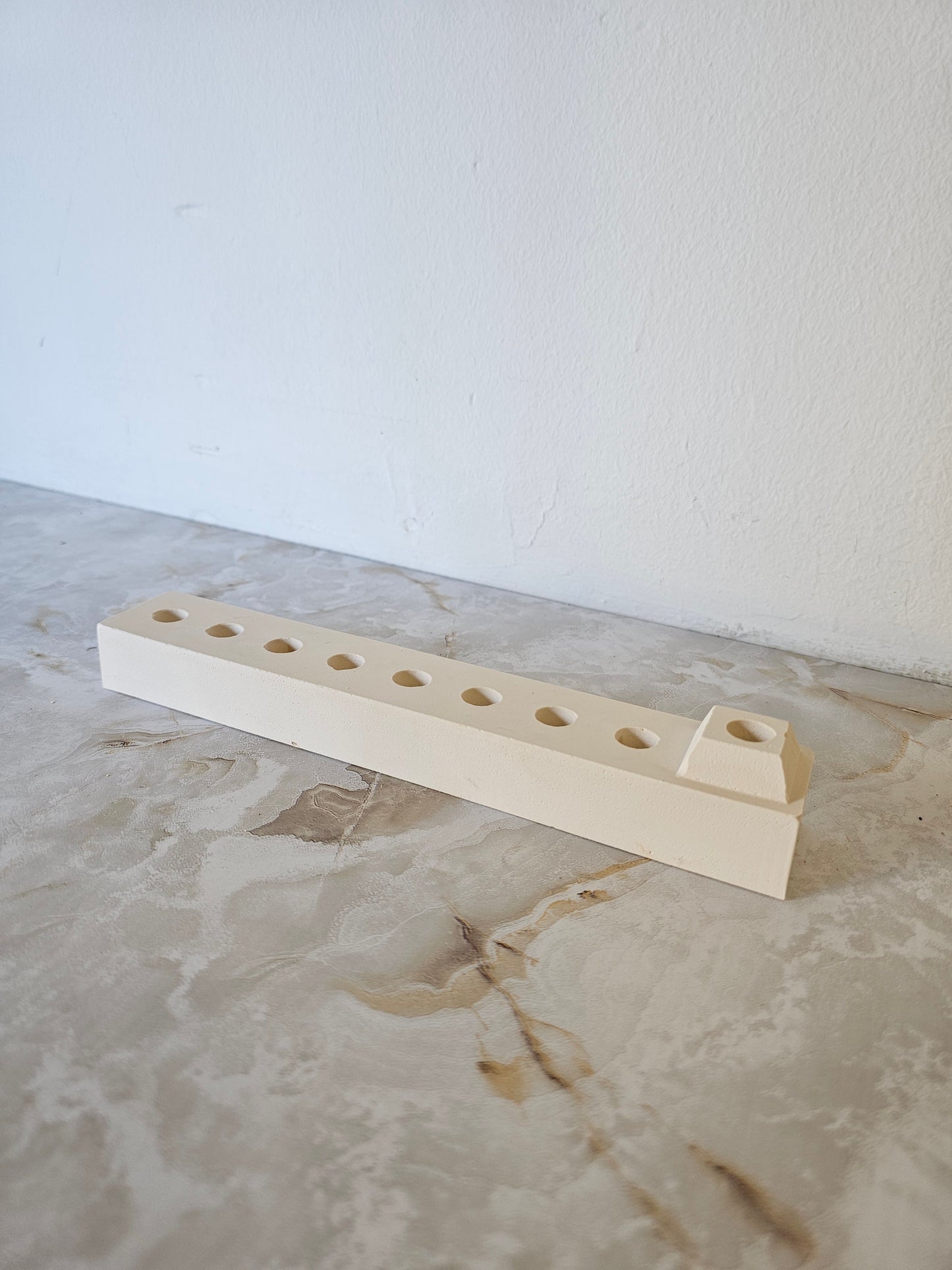 Modern handmade concrete menorah with 9 candle holders in a clean natural finish, perfect for elegant Hanukkah décor