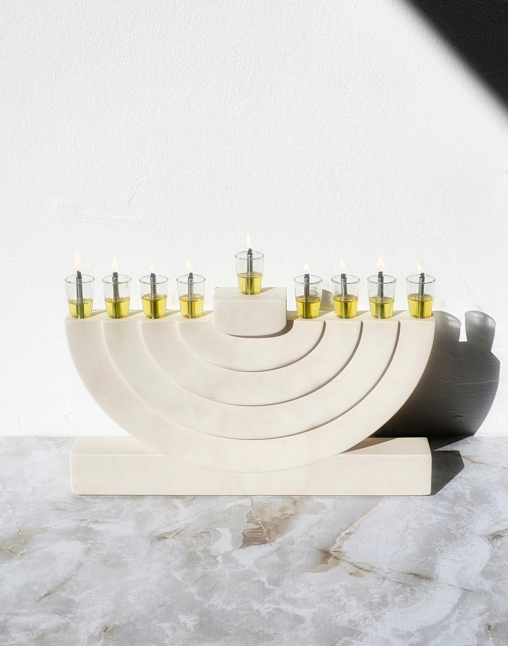 Handcrafted stone-look luxury menorah with layered arch design and glass oil cups, created for a modern elegant Hanukkah home